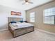 Bright main bedroom with large windows, a cozy king-sized bed, and a ceiling fan at 5807 Circa Fishhawk Blvd, Lithia, FL 33547