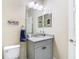 Powder room features vanity with granite countertop, a decorative mirror, and 'Beach Life' decor at 5807 Circa Fishhawk Blvd, Lithia, FL 33547