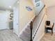 Carpeted stairs with white wood railing lead to the upper level in this bright, modern home at 5807 Circa Fishhawk Blvd, Lithia, FL 33547