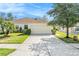 Charming single-story home with a well-manicured lawn and a two-car garage under a sunny blue sky at 5836 Autumn Shire Dr, Zephyrhills, FL 33541