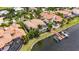 Aerial view of waterfront home with tile roof, dock, boat lift, screened lanai, and lush tropical landscaping at 624 Balibay Rd, Apollo Beach, FL 33572