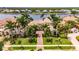 Stately home featuring a paver driveway, impeccable lawn, and swaying palm trees at 624 Balibay Rd, Apollo Beach, FL 33572