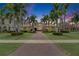 Elegant Mediterranean style home with a long driveway lined with palm trees and manicured landscaping at 624 Balibay Rd, Apollo Beach, FL 33572