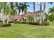Beautiful home exterior with lush landscaping, a well-manicured lawn, and stately palm trees at 624 Balibay Rd, Apollo Beach, FL 33572