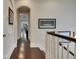 Long hallway with dark wood floors, an arched doorway, and picture frame molding at 624 Balibay Rd, Apollo Beach, FL 33572