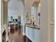 Hallway displaying decorative wall hangings, dark wood floors, and a view into the living room through arched doorways at 624 Balibay Rd, Apollo Beach, FL 33572