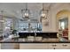 Modern kitchen featuring black granite countertops, stainless steel sink, and decorative pendant lighting fixtures at 624 Balibay Rd, Apollo Beach, FL 33572