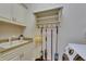 Bright laundry room with white cabinets, a sink, cleaning supplies, and a modern washer-dryer unit at 624 Balibay Rd, Apollo Beach, FL 33572