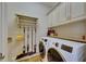Well-organized laundry room featuring white cabinets, cleaning supplies, and a modern washer and dryer at 624 Balibay Rd, Apollo Beach, FL 33572