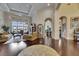 Spacious living room with dark wood floors, arched doorways, and access to an outdoor living space at 624 Balibay Rd, Apollo Beach, FL 33572