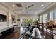 Bright living room with multiple windows, fan, entertainment center, and a sliding door to a balcony at 624 Balibay Rd, Apollo Beach, FL 33572