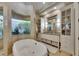 Tranquil bathroom with a garden tub, glass block window, and granite countertops at 624 Balibay Rd, Apollo Beach, FL 33572