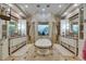 Luxurious bathroom featuring a large soaking tub, dual vanities, and travertine tile at 624 Balibay Rd, Apollo Beach, FL 33572