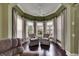Inviting sitting area with bay windows, plantation shutters, neutral drapes, and comfortable armchairs at 624 Balibay Rd, Apollo Beach, FL 33572