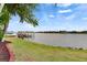 Scenic waterfront view featuring a private dock, boat lift, lush greenery, and beautiful houses in the background at 624 Balibay Rd, Apollo Beach, FL 33572