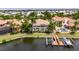 Aerial view of a waterfront property with a pool, boat dock, and lush landscaping on a sunny day at 624 Balibay Rd, Apollo Beach, FL 33572