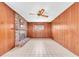 A cozy living area with a brick fireplace, wood walls, tile floor, and a ceiling fan at 6638 12Th N Ter, St Petersburg, FL 33710