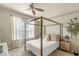 Well-lit bedroom featuring a canopy bed, large window with white curtains, neutral walls, and stylish decor at 700 S Harbour Island Blvd # 105, Tampa, FL 33602
