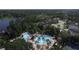 Wide aerial view showcasing community amenities: resort-style pools, lush landscaping, and beautiful water features at 7334 Night Heron Dr, Land O Lakes, FL 34637
