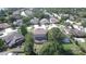 Aerial view of a quiet residential neighborhood showcasing a home with an enclosed patio and mature landscaping at 7334 Night Heron Dr, Land O Lakes, FL 34637