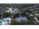 Aerial view of community pool, tennis courts, and lush landscaping nestled within a serene residential area at 7334 Night Heron Dr, Land O Lakes, FL 34637