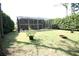 Expansive backyard with lush green grass and a screened enclosure at 7334 Night Heron Dr, Land O Lakes, FL 34637