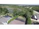 Aerial shot of the backyard with screen enclosed pool, lush greenery and neighborhood pond at 7334 Night Heron Dr, Land O Lakes, FL 34637