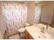 Bright bathroom featuring a single sink vanity and floral shower curtain at 7334 Night Heron Dr, Land O Lakes, FL 34637