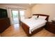 Cozy bedroom featuring wood floors, a sliding door to a porch, and neutral decor at 7334 Night Heron Dr, Land O Lakes, FL 34637