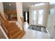 Bright foyer with tile flooring, a wooden staircase, and a decorative glass front door at 7334 Night Heron Dr, Land O Lakes, FL 34637