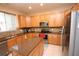 A gourmet kitchen features wood cabinetry, a center island, and stainless steel appliances at 7334 Night Heron Dr, Land O Lakes, FL 34637