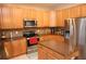 Gourmet kitchen features wood cabinetry, center island, and stainless steel appliances at 7334 Night Heron Dr, Land O Lakes, FL 34637