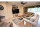 Comfortable living room with neutral paint, tile flooring, plush couches, and a large entertainment center at 7334 Night Heron Dr, Land O Lakes, FL 34637