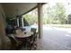 Covered patio features an outdoor dining set with decorative chairs overlooking the enclosed pool and garden at 7334 Night Heron Dr, Land O Lakes, FL 34637