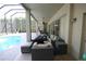 Spacious covered patio features outdoor furniture with a view of the cool blue pool and tropical foliage at 7334 Night Heron Dr, Land O Lakes, FL 34637