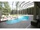 Enclosed pool features cool blue water, brick pavers, a jacuzzi and an attached seating area for relaxing poolside at 7334 Night Heron Dr, Land O Lakes, FL 34637