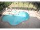 Aerial view of an in-ground pool and hot tub surrounded by a screened enclosure at 7334 Night Heron Dr, Land O Lakes, FL 34637