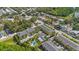 Aerial view showcasing the neighborhood with residential buildings, a community pool, and lush greenery at 789 Grand Cypress Ln, Tarpon Springs, FL 34689