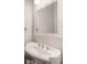 Bathroom features a white pedestal sink, decorative mirror, and modern fixtures at 789 Grand Cypress Ln, Tarpon Springs, FL 34689