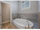 Bright bathroom features a soaking tub with tile surround and neutral color palette at 789 Grand Cypress Ln, Tarpon Springs, FL 34689
