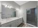 Bright bathroom featuring double sinks, white cabinetry, and a large mirror at 789 Grand Cypress Ln, Tarpon Springs, FL 34689