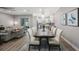 Bright dining room featuring a wood table, white chairs, and an open layout to the kitchen and living area at 789 Grand Cypress Ln, Tarpon Springs, FL 34689