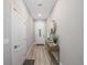 Hallway with wood floors featuring a console table with decor and a white front door at 789 Grand Cypress Ln, Tarpon Springs, FL 34689