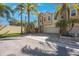 Charming tan townhome with a two-car garage, beautiful palm trees, and a brick-paved driveway at 789 Grand Cypress Ln, Tarpon Springs, FL 34689