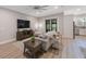 Bright and airy living room featuring modern decor, hardwood floors, and a sliding door to the outside at 789 Grand Cypress Ln, Tarpon Springs, FL 34689