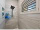 Elegant shower with stylish tile, a rain shower head, and a convenient shower caddy at 789 Grand Cypress Ln, Tarpon Springs, FL 34689
