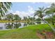 Scenic backyard view with pond, palm trees and green grass, creating a serene setting at 815 Silverthorn Ln # 0, Sun City Center, FL 33573