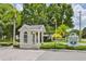 Community entrance featuring a brick guard house and lush tropical foliage at 815 Silverthorn Ln # 0, Sun City Center, FL 33573