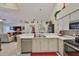 Open concept kitchen features stainless steel appliances, light countertops, and seamlessly connects to living area at 815 Silverthorn Ln # 0, Sun City Center, FL 33573