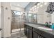 Luxurious bathroom showcasing a glass-enclosed shower, granite countertop, and elegant lighting at 8228 Sunlit Horizon Ln, Land O Lakes, FL 34637